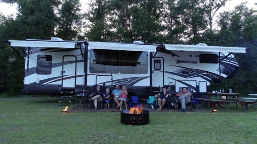 Picture of the Parks' sitting outside their camper