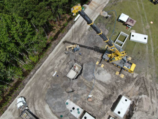 aerial Picture of large crane setting a septic tank.