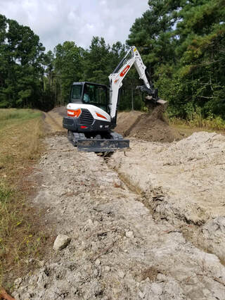 Picture of Shawn digging the ditch on the south side of property