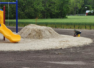Picture of our grandson playing in the sand with his truck and skid steer.