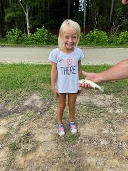 Picture of Emma 5 years old and the bass she caught in our pond.